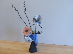 Vase cornet bleu fleurs sur tiges.